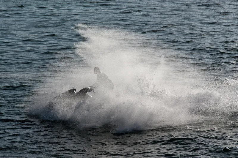 Moto de agua levantando una cortina de spray sobre el mar